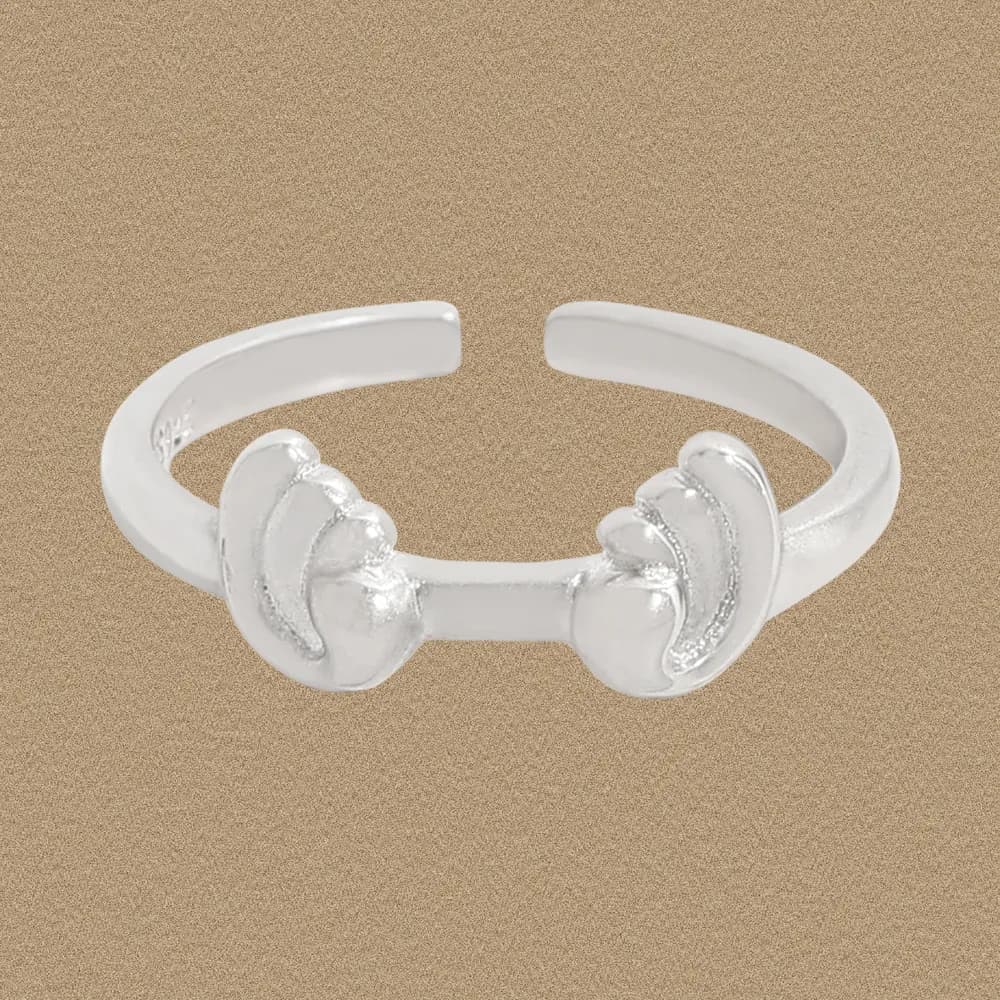 Open-ended sterling silver ring with petal-like ends on a neutral background.