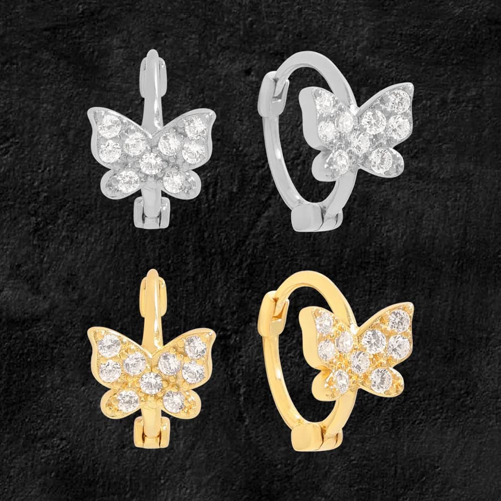 Polished hoop earrings with a butterfly-shaped crystal cluster charm on a dark background.