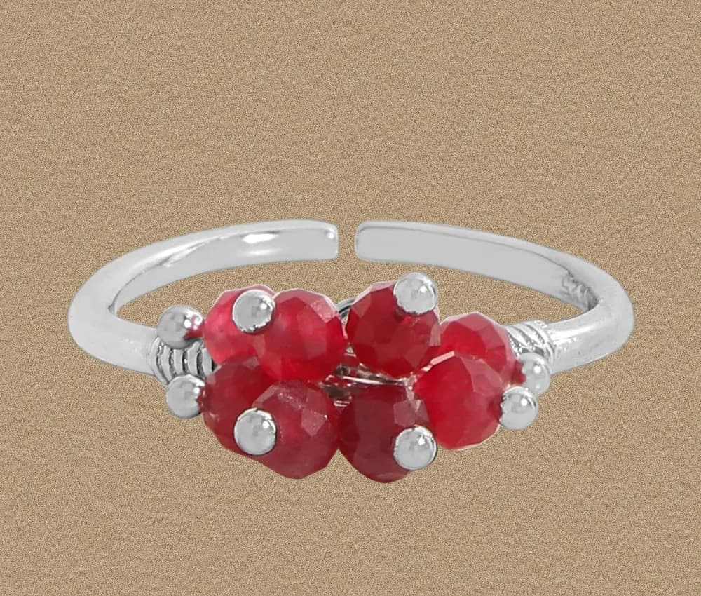 Open sterling silver ring with a cluster of red faceted beads at the center.