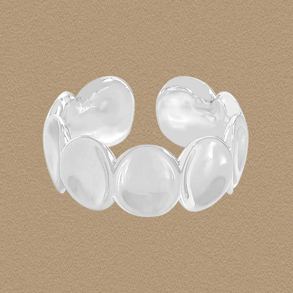 Polished sterling silver ring made of connected circular discs on a finger-like background