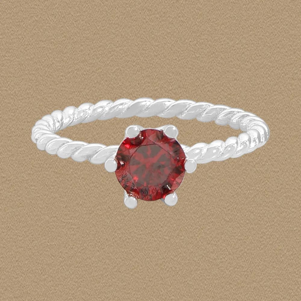 A sterling silver twisted rope ring with a round red gemstone centerpiece