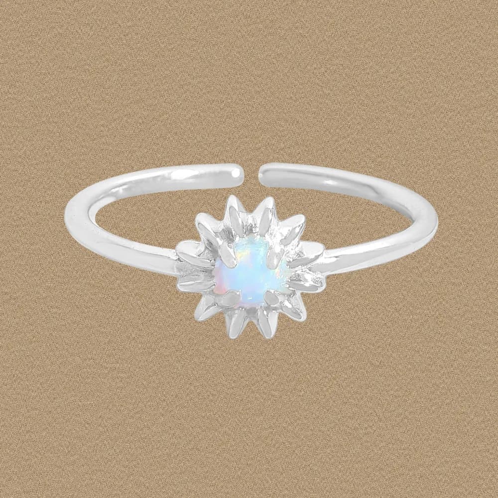 Sterling silver ring with a sunburst bezel holding an iridescent opal center