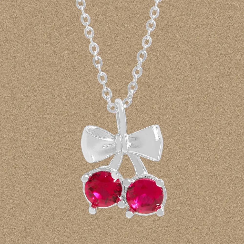 Polished silver bow pendant with two red stones on a fine chain
