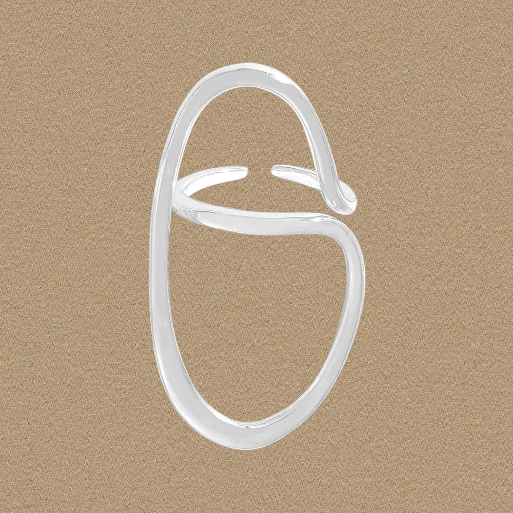 Polished sterling silver Open Oval Ring with an abstract crossbar on a warm beige background.