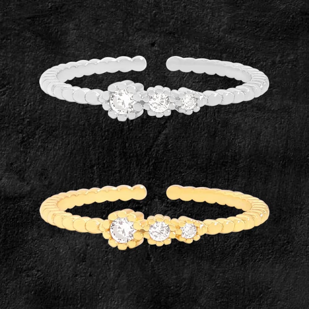 Polished silver beaded disc ring with three-flower centerpiece shown beside a gold-tone version against a dark background.