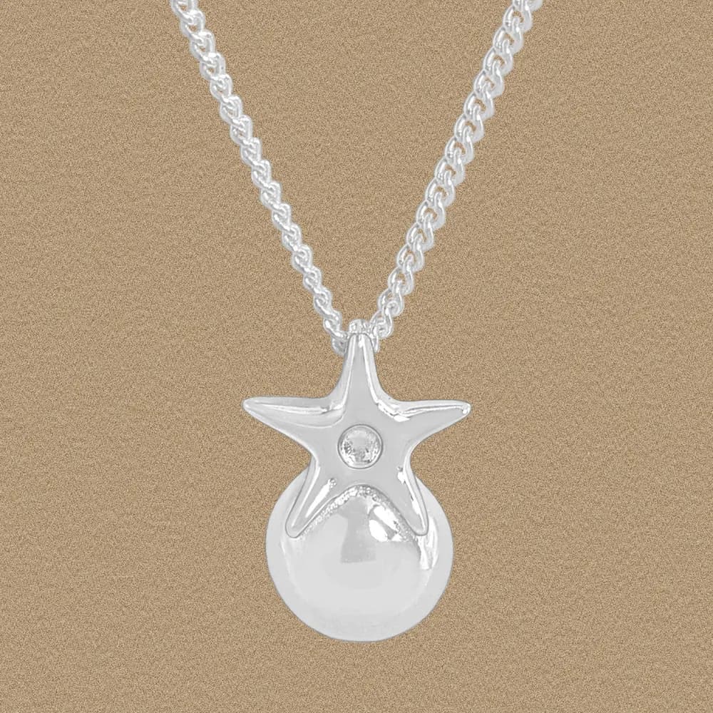 Polished sterling silver star pendant with a gemstone on a rounded drop bead hangs from a chain
