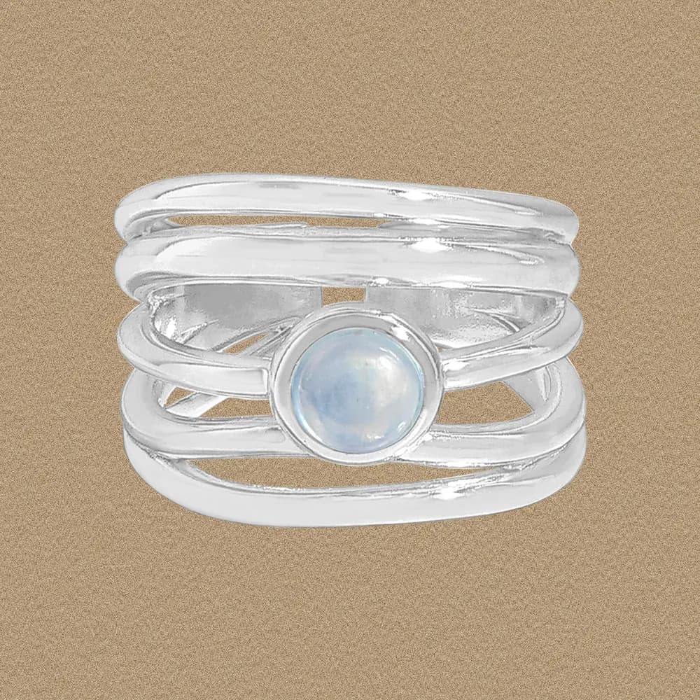 Sterling silver multi-band ring with a bezel-set moonstone centerpiece on a neutral background.