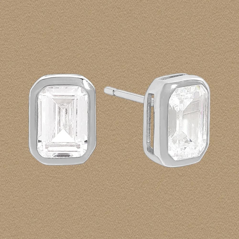 Two sterling silver emerald-cut crystal stud earrings with bezel settings and posts
