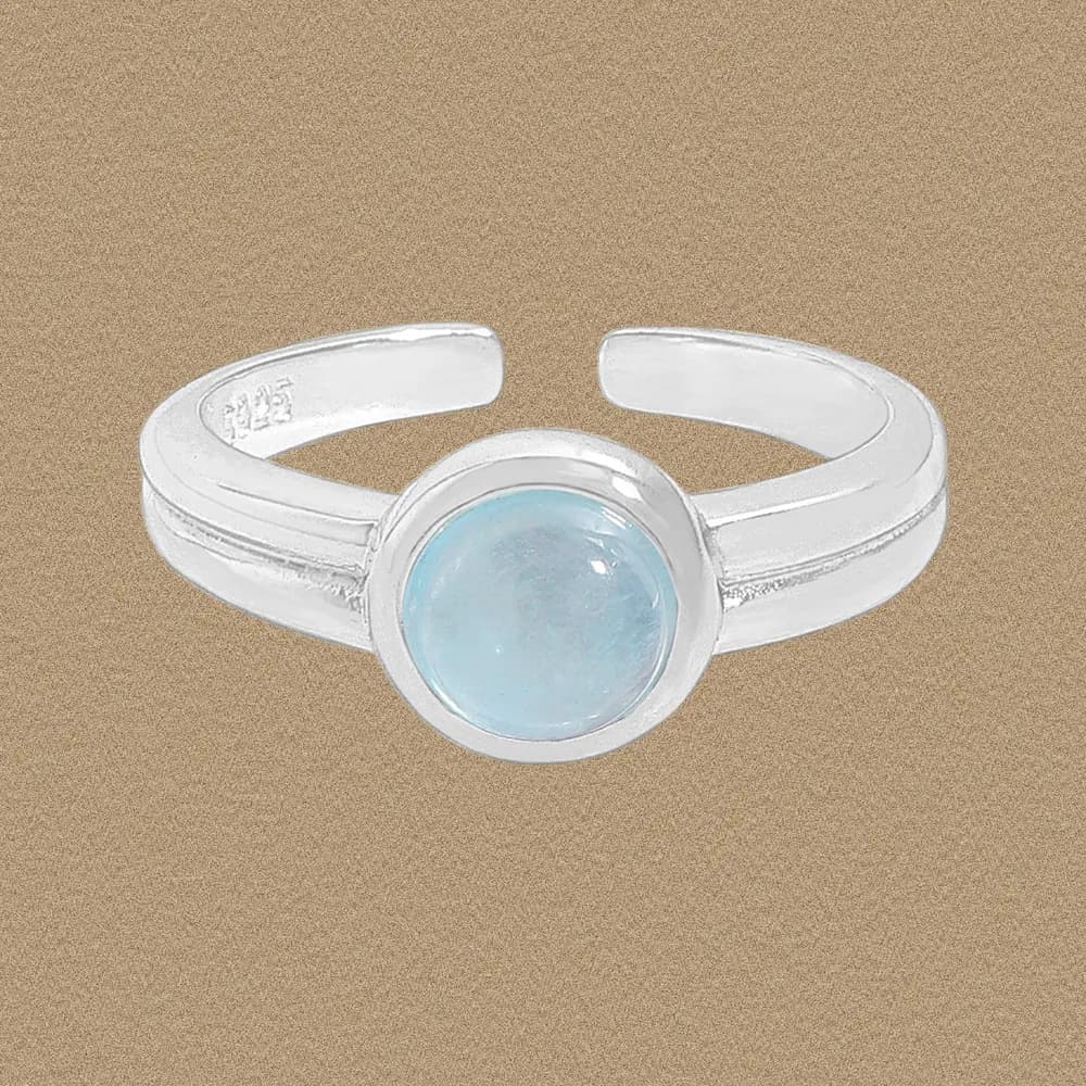 Sterling silver ring with a round light-blue cabochon bezel-set on a double-band shank.