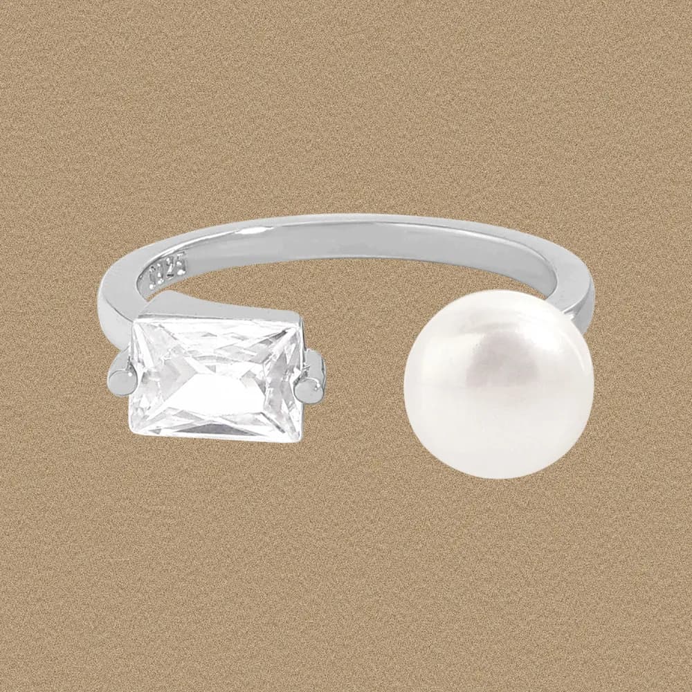 Polished sterling silver open ring with emerald-cut stone on one end and a pearl on the other.