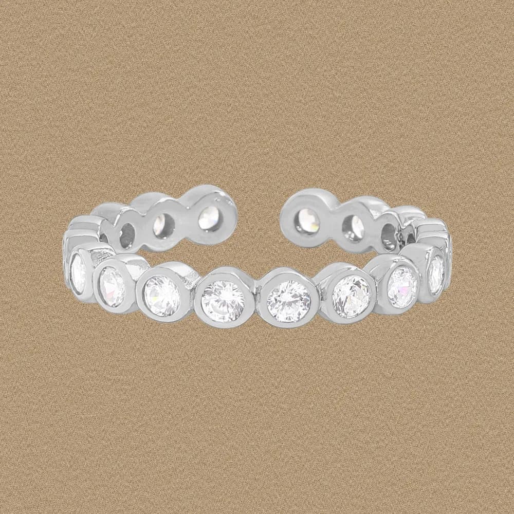 Polished sterling silver ring featuring bezel-set round stones in a circular band with an open back