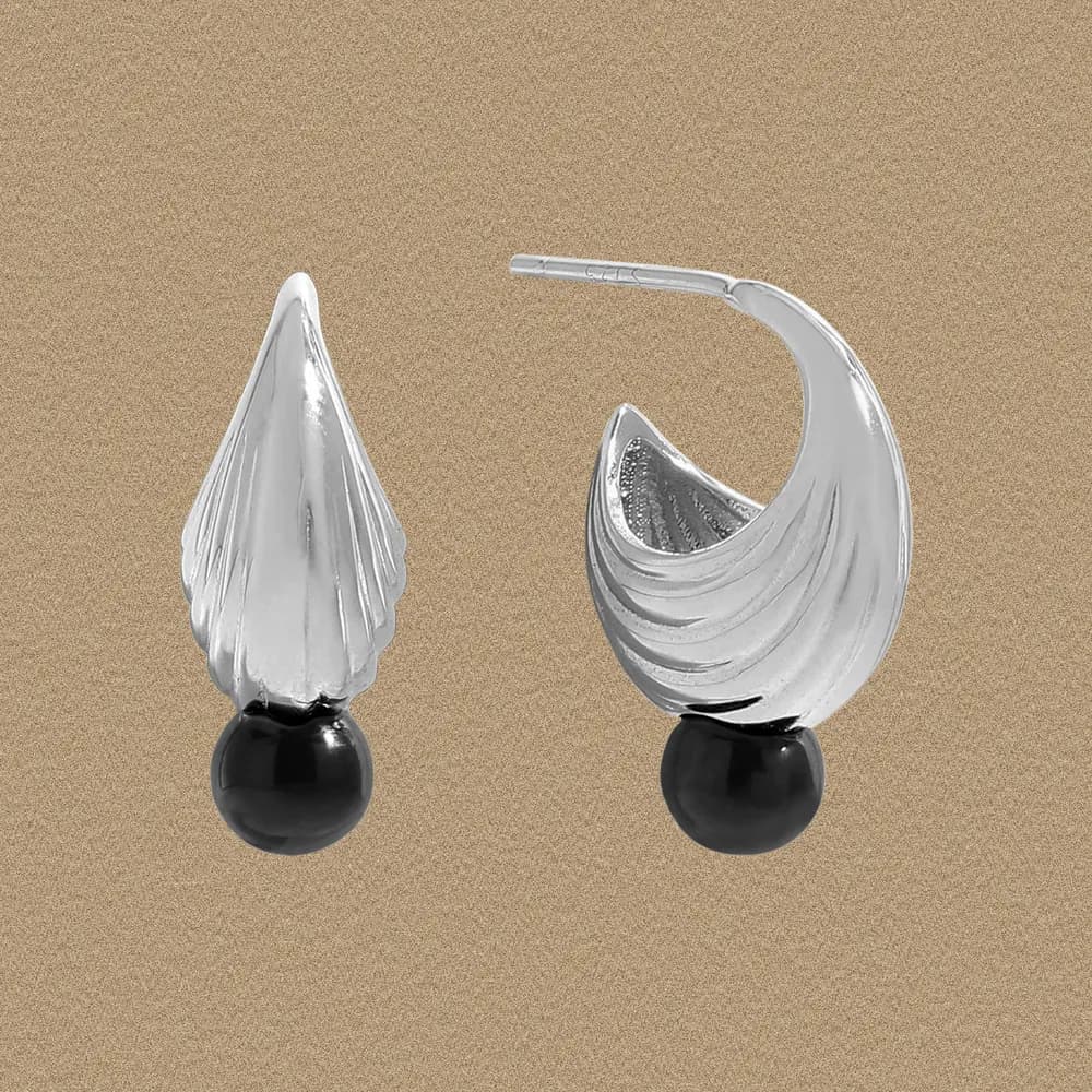 Polished sterling silver crescent earrings with ribbed texture and black bead at the base.