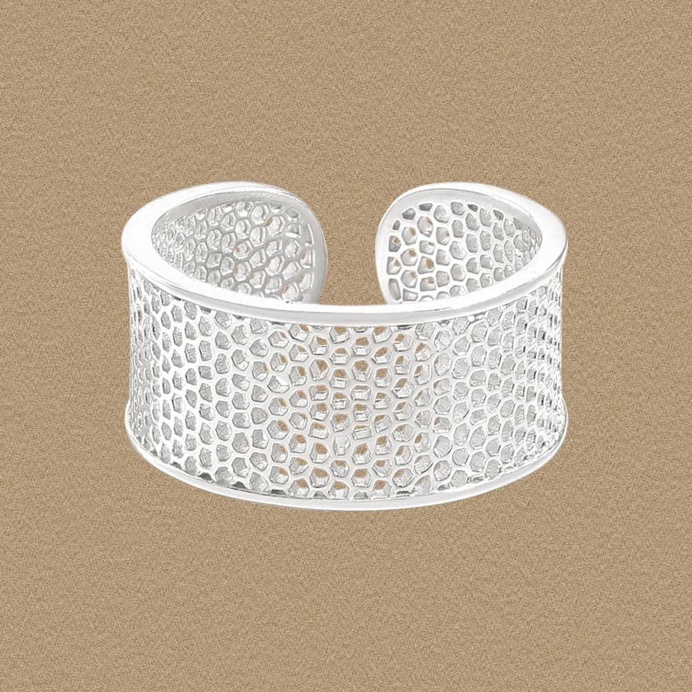 Wide sterling silver cuff-style ring with a honeycomb mesh pattern on a warm background.