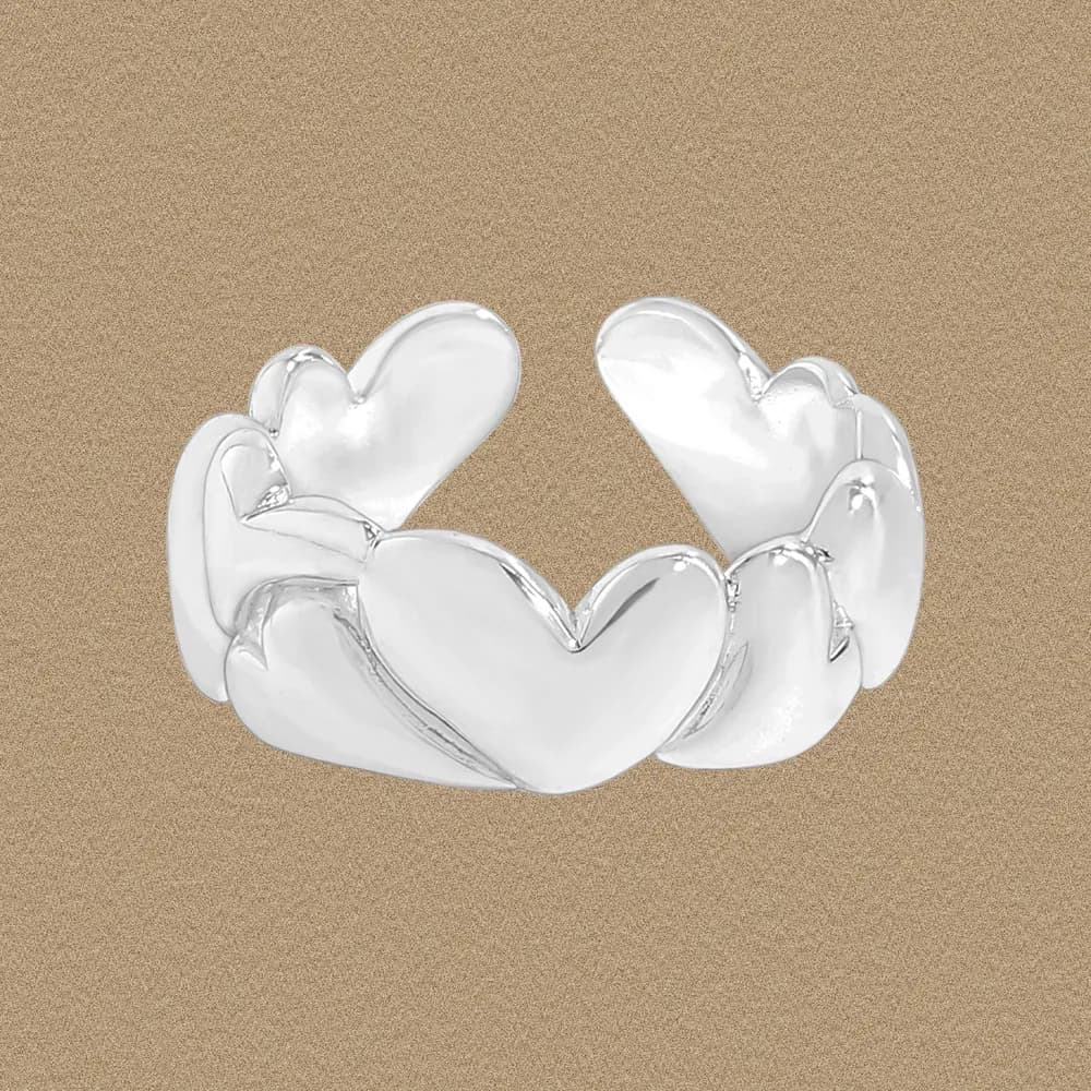 Polished sterling silver ring with a cluster of interconnected heart shapes forming a sculptural band.