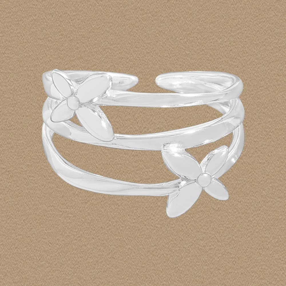 Polished sterling silver double-band ring with two floral end motifs on a neutral background.