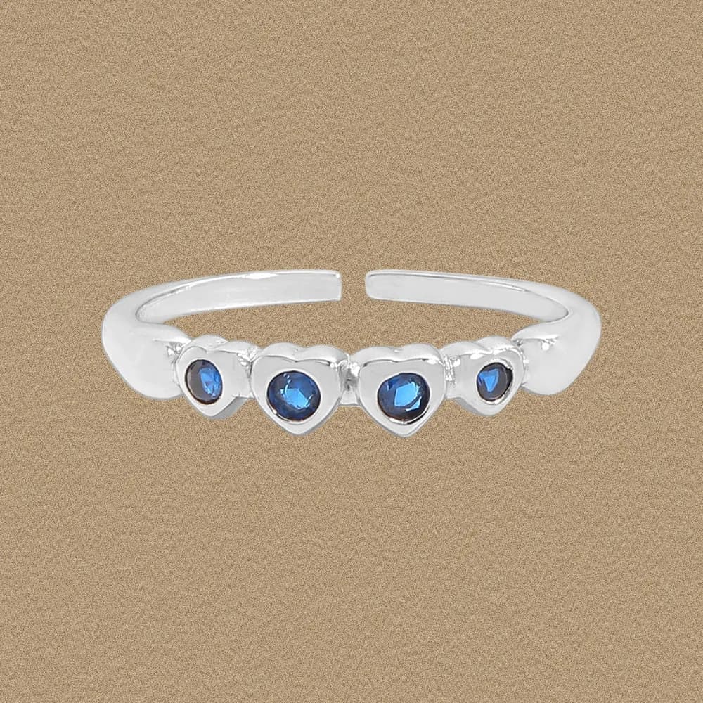 Polished sterling silver ring with five heart-shaped blue stone bezels along an open band.