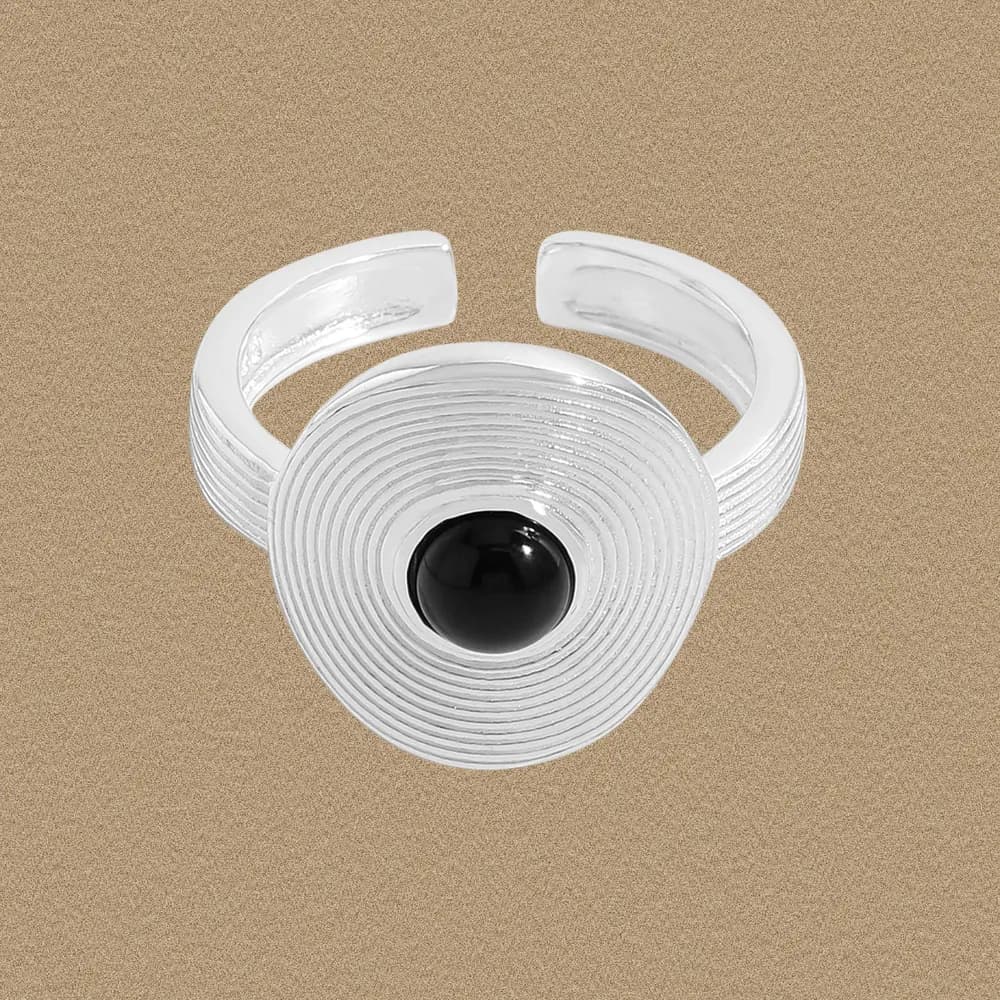 Polished sterling silver ring with concentric grooved disc and black onyx cabochon center