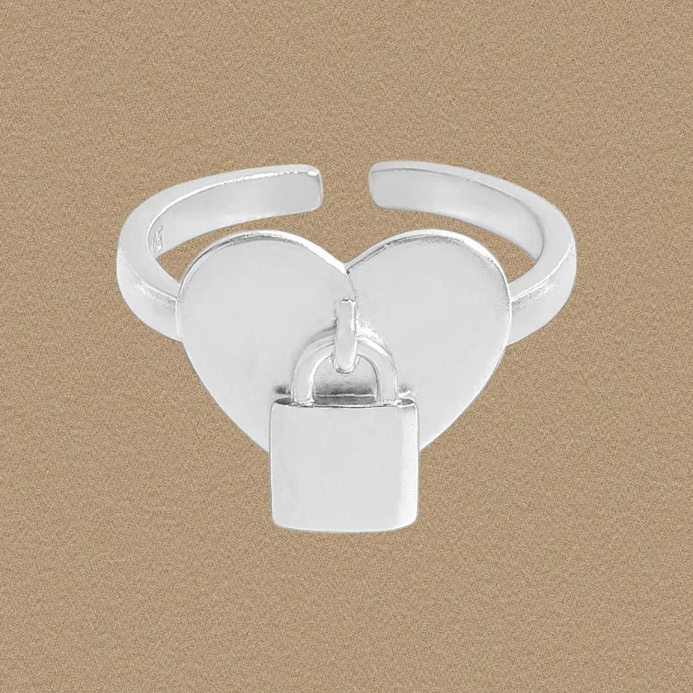 Polished sterling silver open-ring with two hearts and a small hanging padlock charm on a muted background.