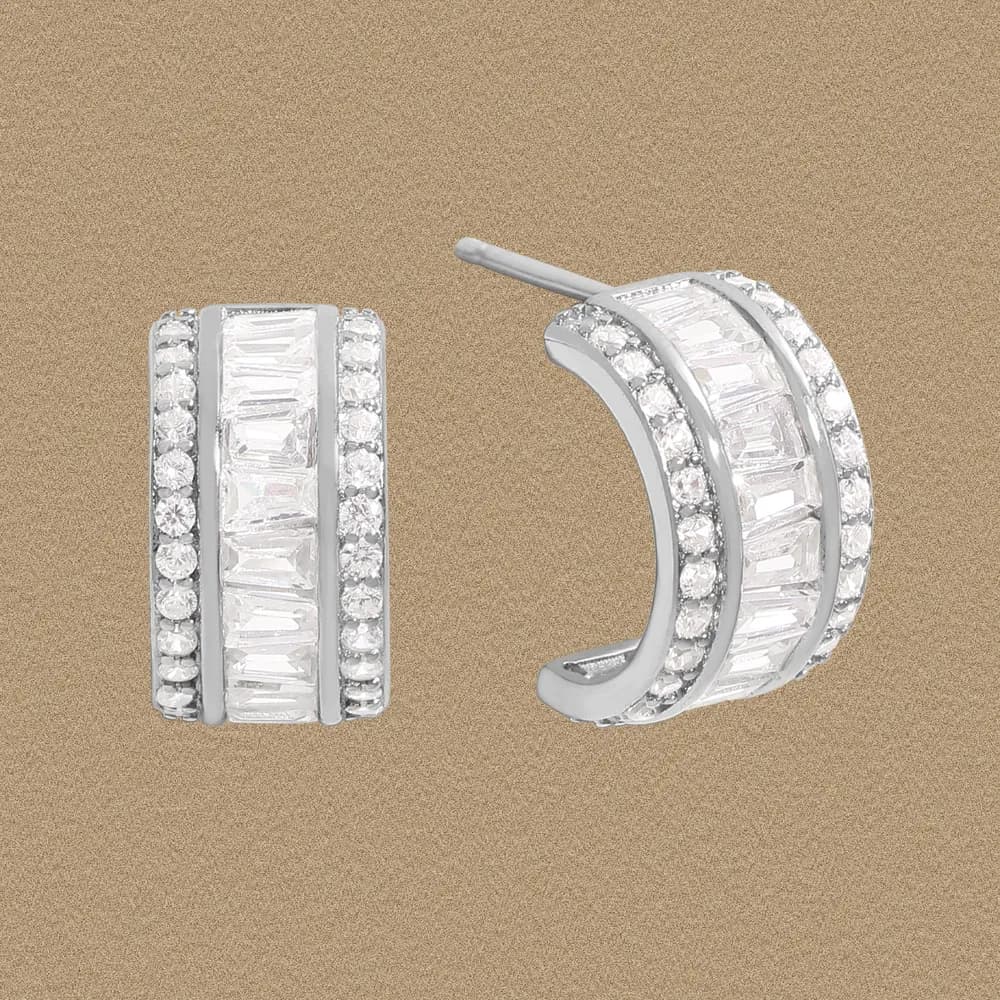 Polished sterling silver hoop earrings with a central baguette row and outer pavé stones, showcasing a curved, contemporary design.
