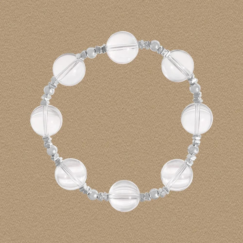 Polished sterling silver bracelet with large translucent ribbed glass beads arranged in a circle on a warm tan background.
