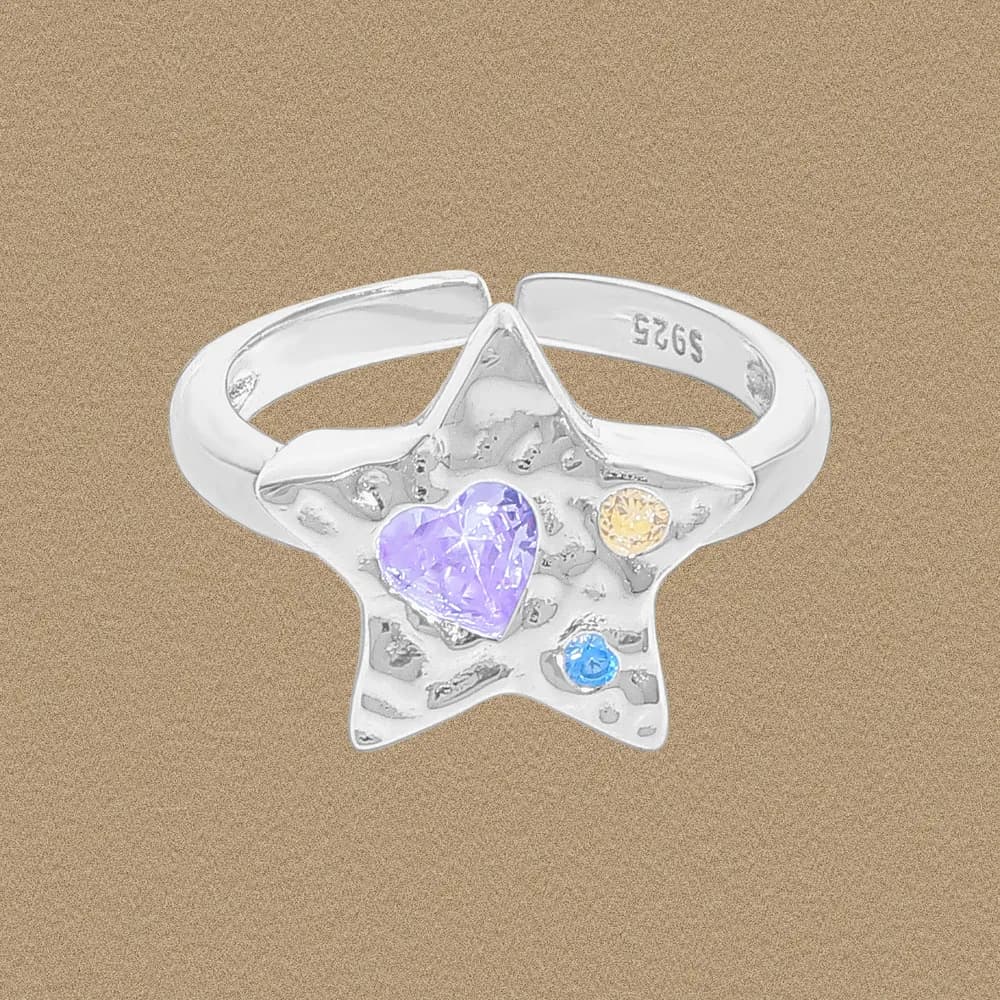 Polished sterling silver star ring with a lavender heart-cut centerpiece and small colored stones on a neutral background.