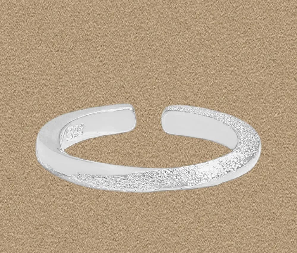 Open silver cuff ring with a textured central band and smooth polished edges.