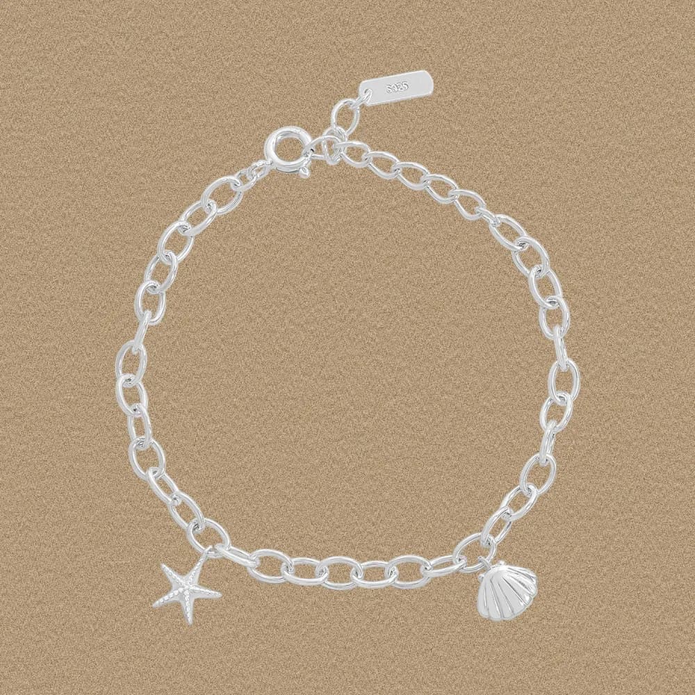 Polished sterling silver bracelet with starfish and shell charms on a rounded linked chain.