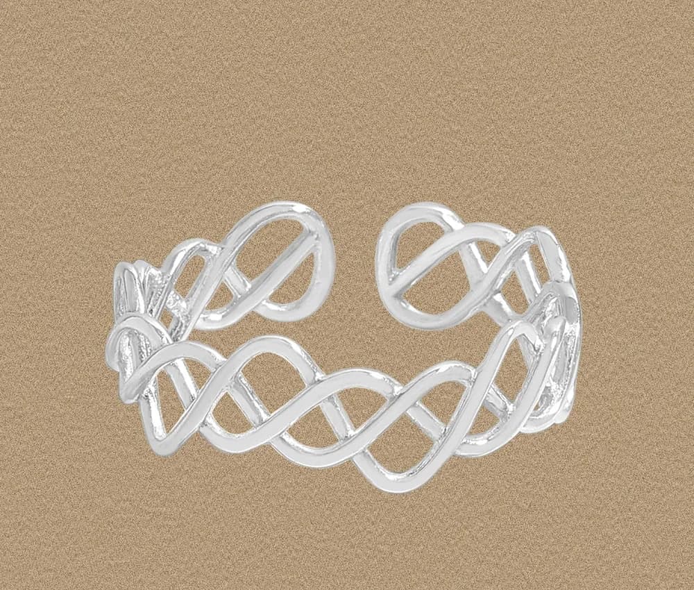 Polished sterling silver interwoven ribbon ring with a wide open lattice design on a sandy background.