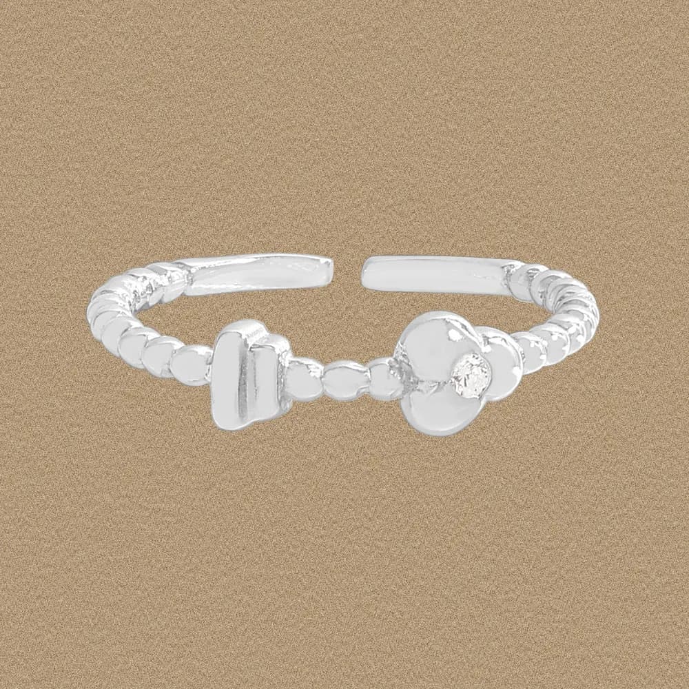 Open-ended sterling silver ring with a beaded band and a small clover-shaped cluster on the front