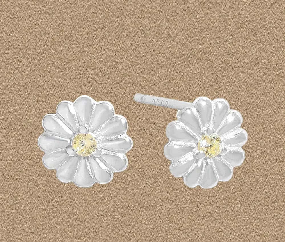 Sterling silver daisy stud earrings with a polished finish and yellow center gemstone.