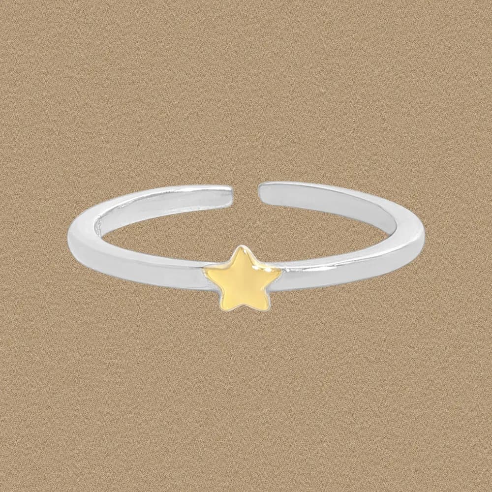 Open sterling silver ring with a small gold star accent at the center front.