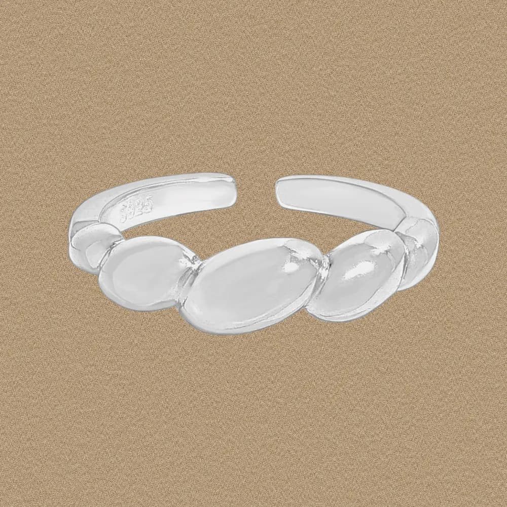 Polished sterling silver open ring featuring three connected oval beads on a soft gold-toned background.