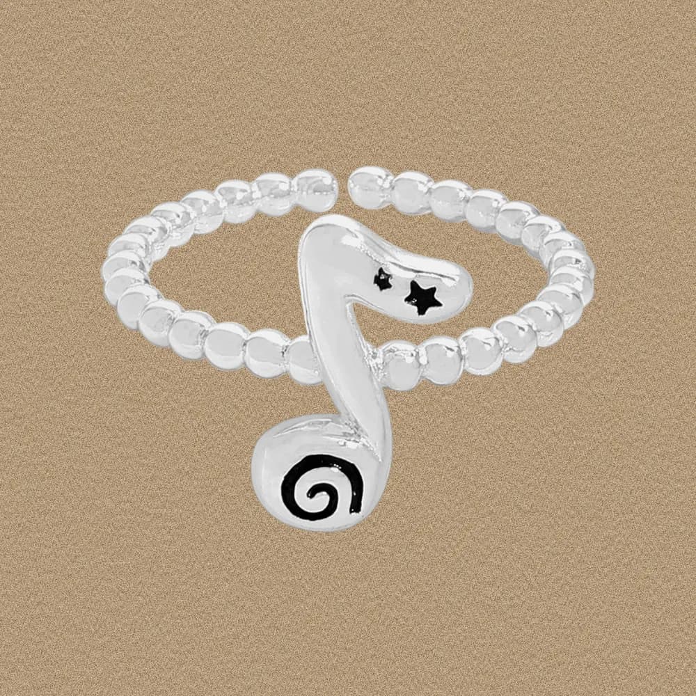 Silver beaded-band ring with a treble-note centerpiece on a beige background.