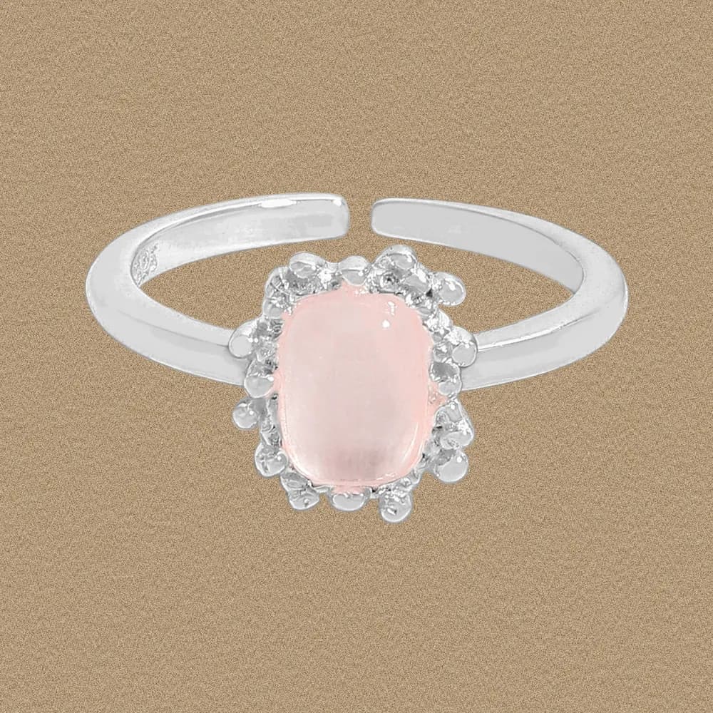 Polished sterling silver ring with an oval pale pink center stone surrounded by a beaded halo.