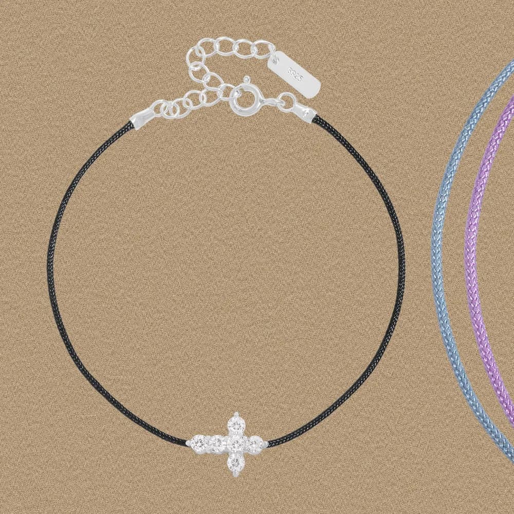Black cord bracelet with a silver pavé-cross charm at the center.