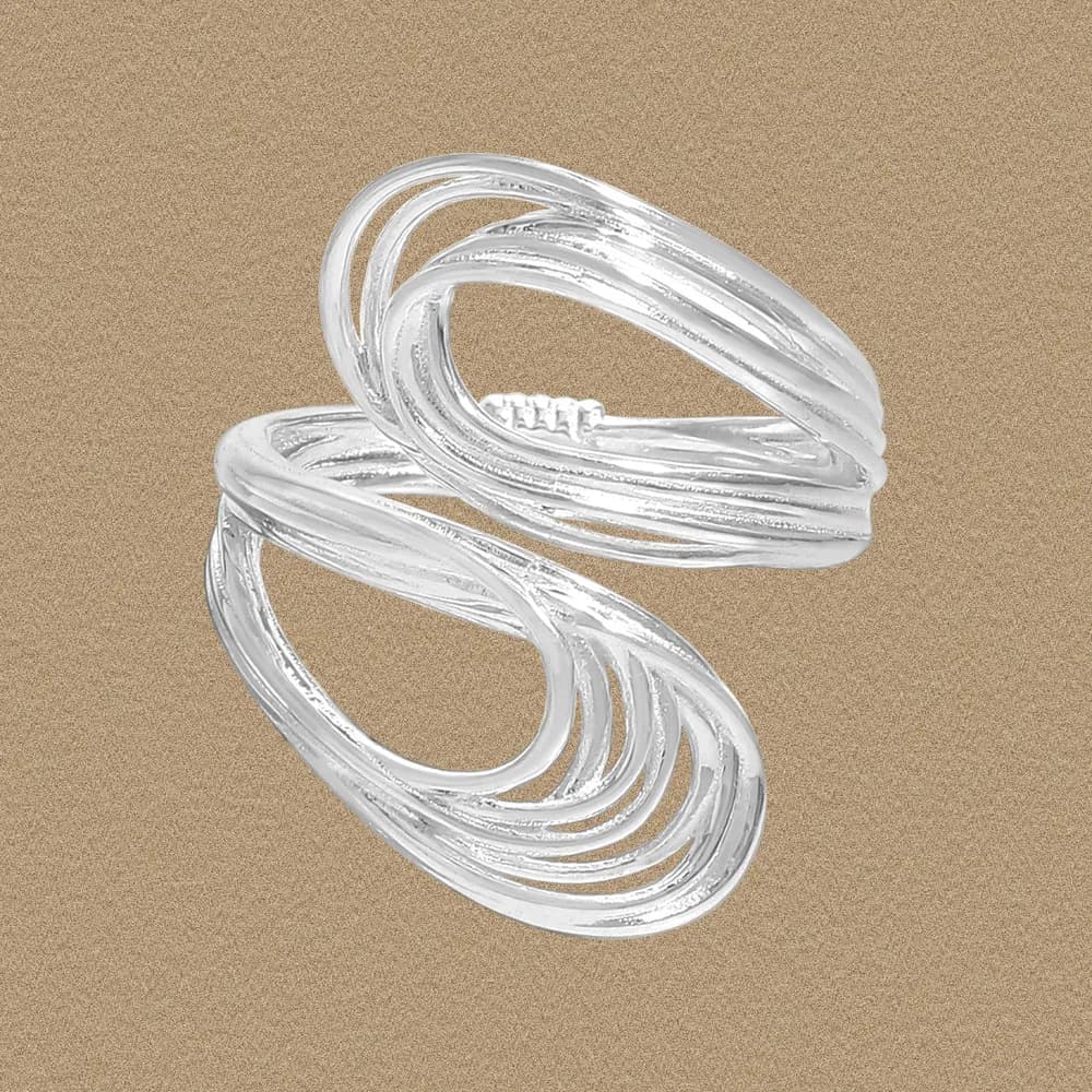 Sterling silver interwoven loop ring with polished bands on a sand-colored background.