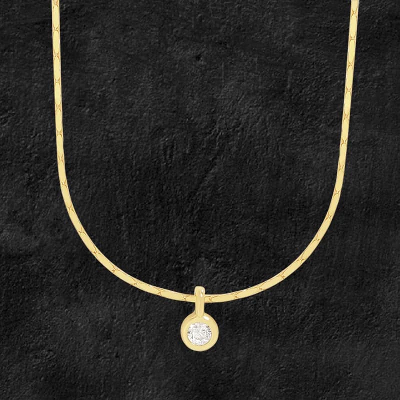 Polished sterling silver necklace with a small round bezel-set pendant on a dark background.
