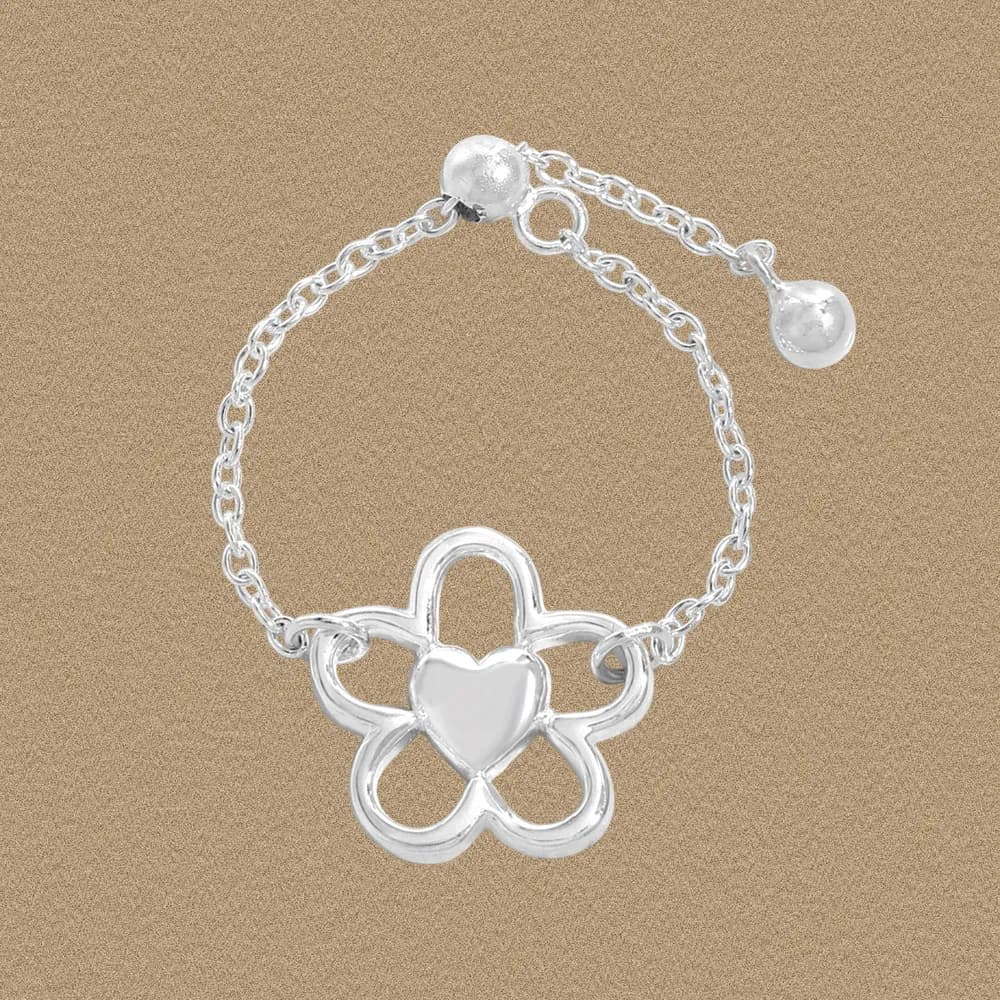 Polished sterling silver ring with a flower-shaped centerpiece and heart in the center.