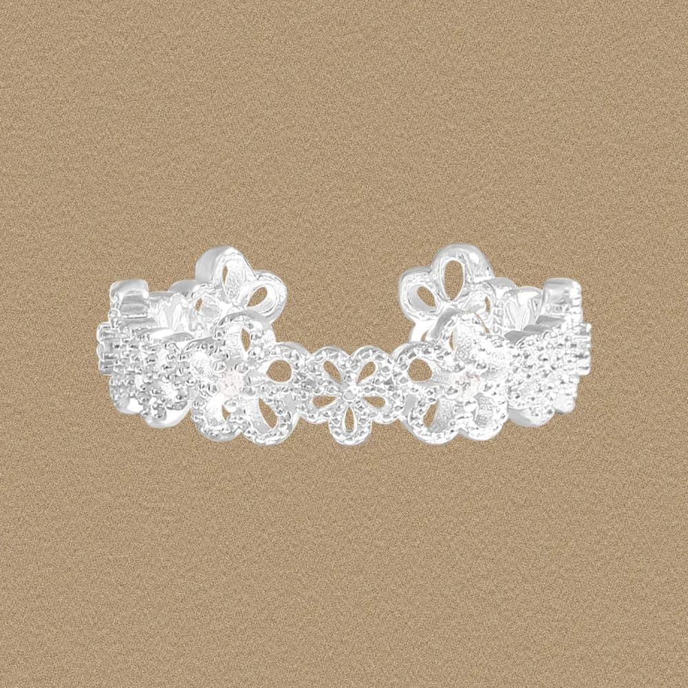 Polished sterling silver lace flower ring with openwork petals on a neutral background.
