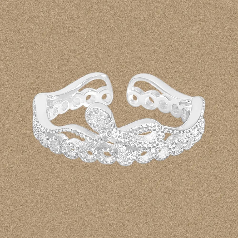 Sterling silver filigree lattice ring with pavé stones and cutout pattern on a tan background.