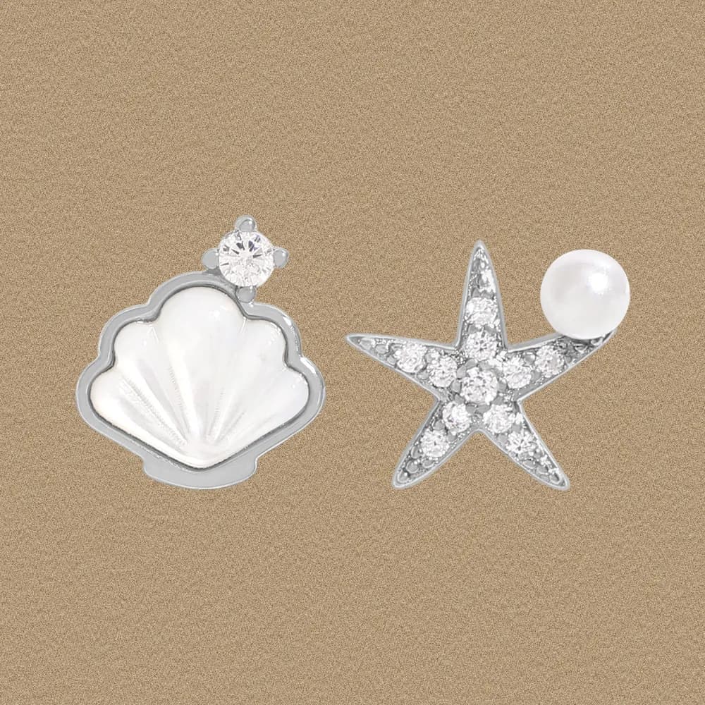 Mismatched shell and starfish earrings in sterling silver with crystals and a pearl accent.