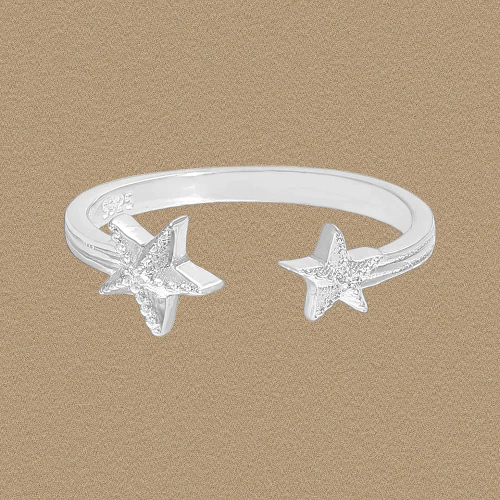 Polished sterling silver ring with two textured starfish ends on a slim band