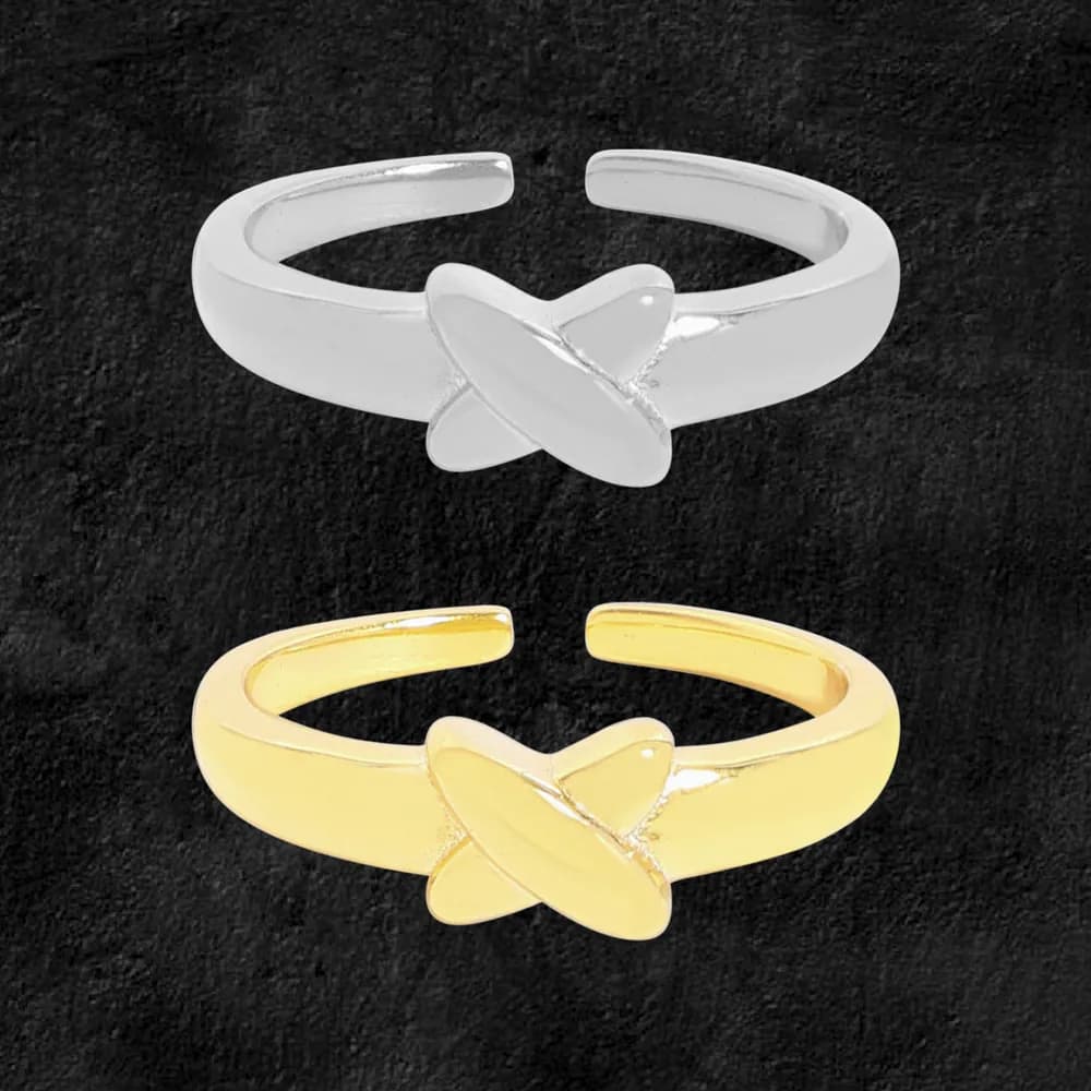 Polished open-band ring with a crossed petal centerpiece in silver on a dark background.