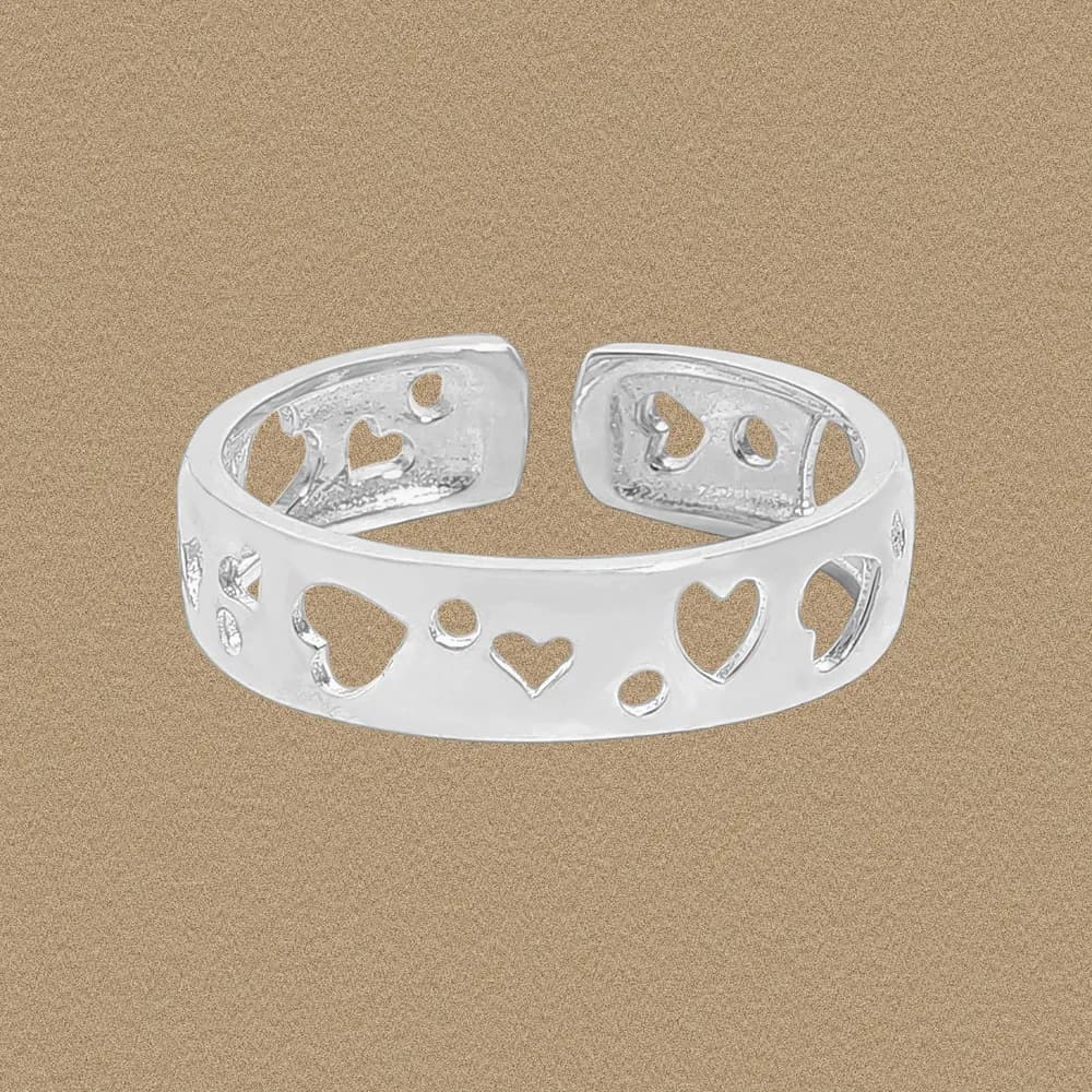 Polished sterling silver ring with open heart and circle cutouts along a wide band.