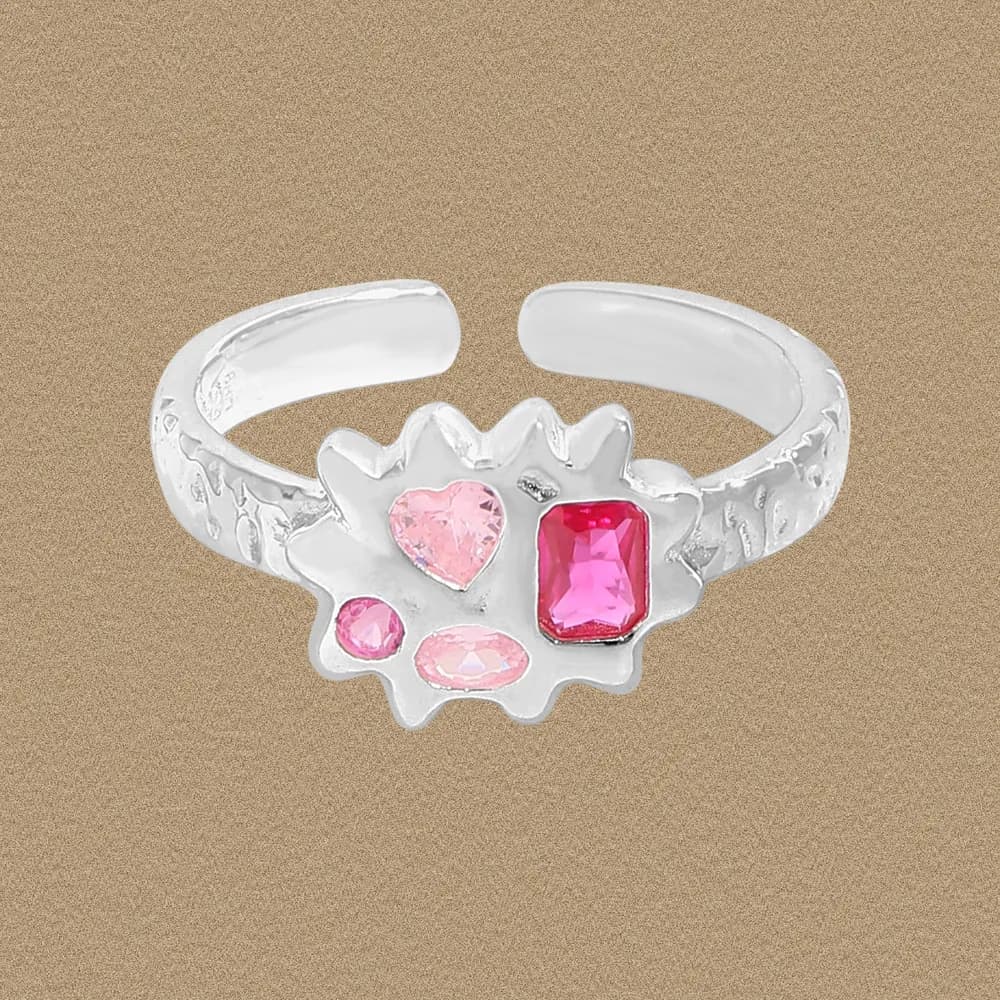 Polished sterling silver ring with a jagged floral centerpiece holding pink stones in varied shapes.
