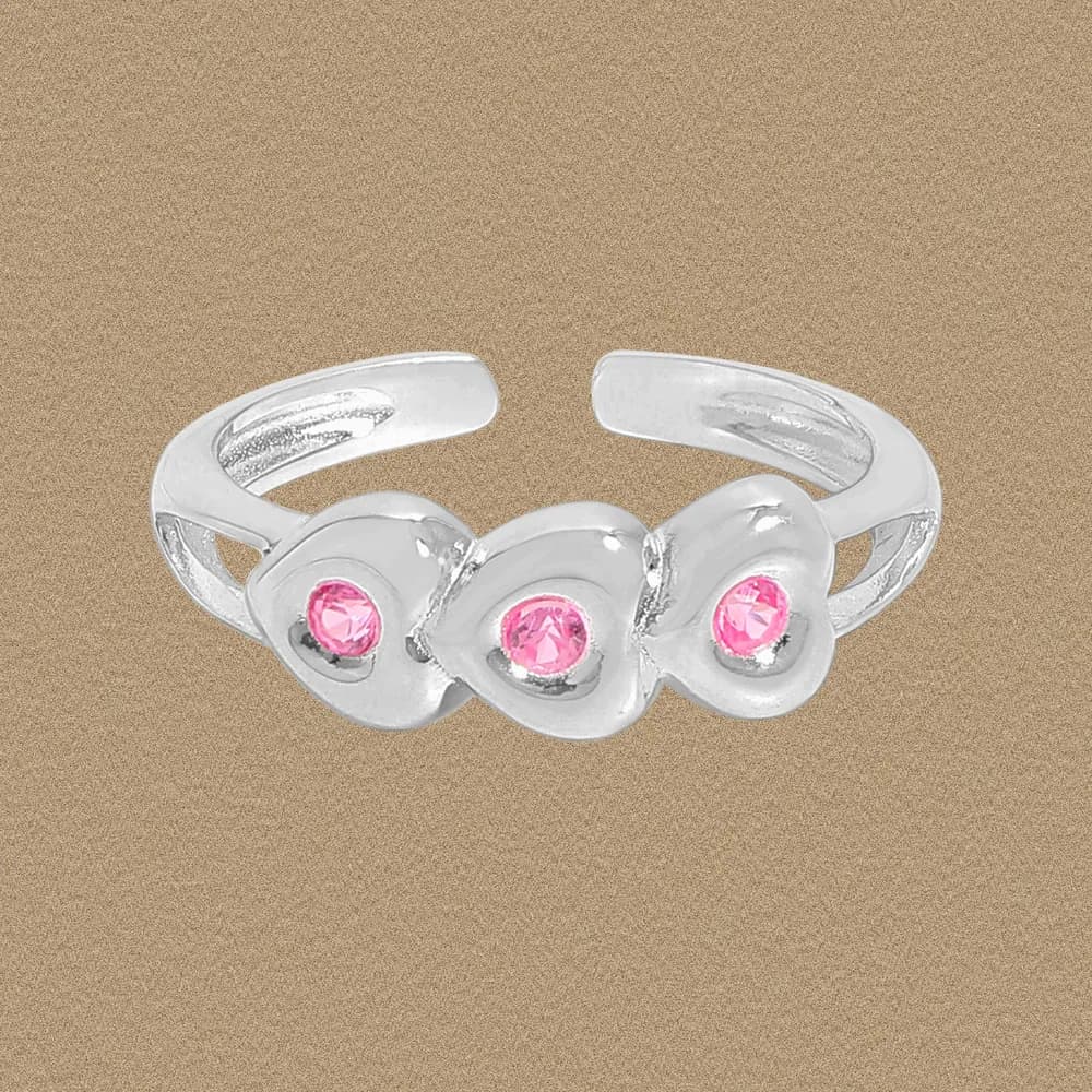 Polished sterling silver ring with three round pink stones set in connected bezel stations along a curved open band.