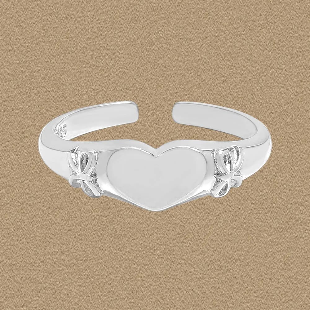 Polished sterling silver open-band ring with a heart centerpiece and decorative side accents.